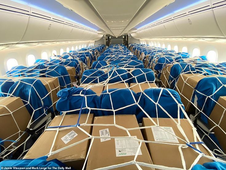 Aircraft cabin filled with cargo boxes secured in transport netting