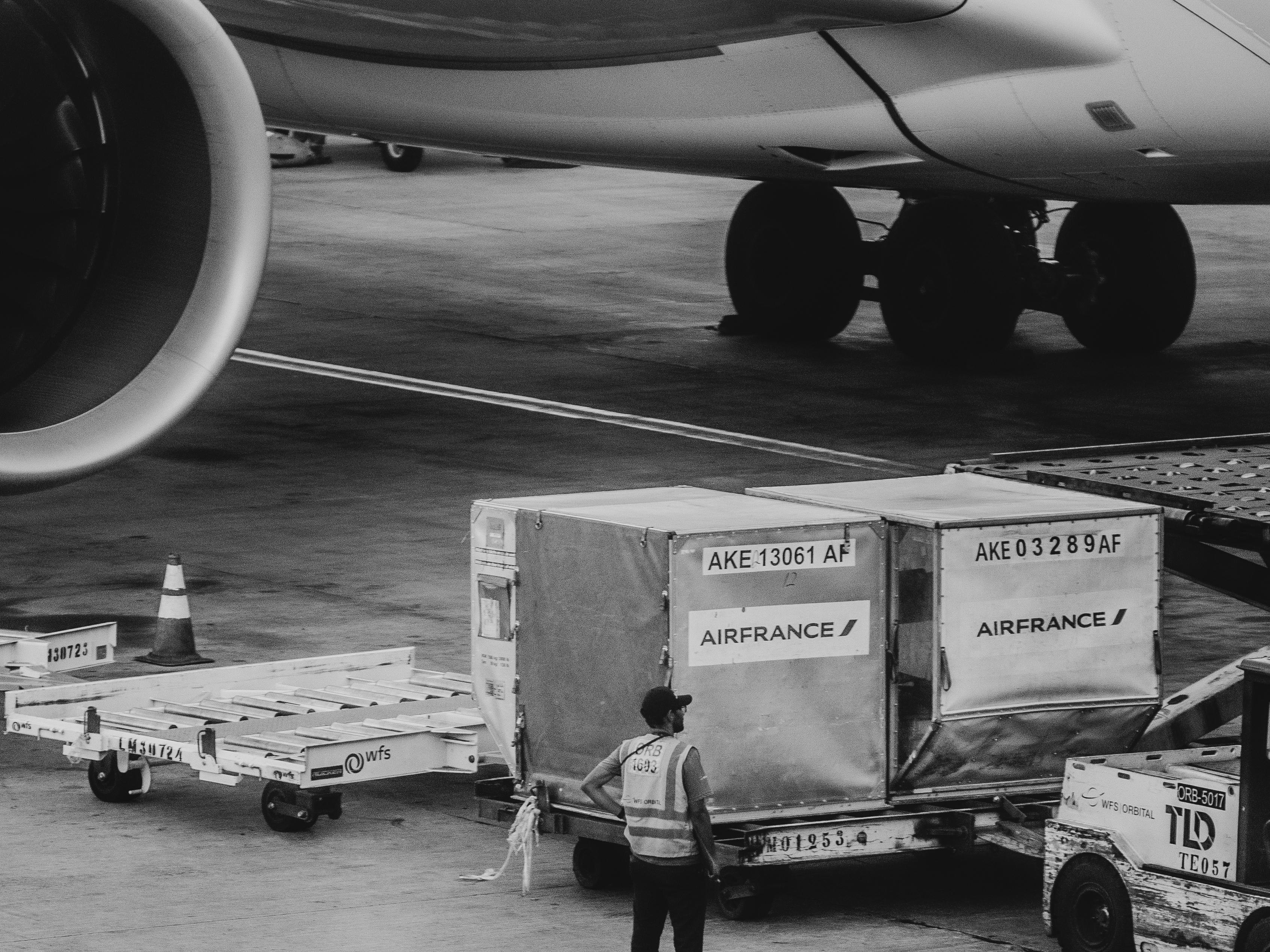Airport ground crew handling an air cargo container beside a plane
