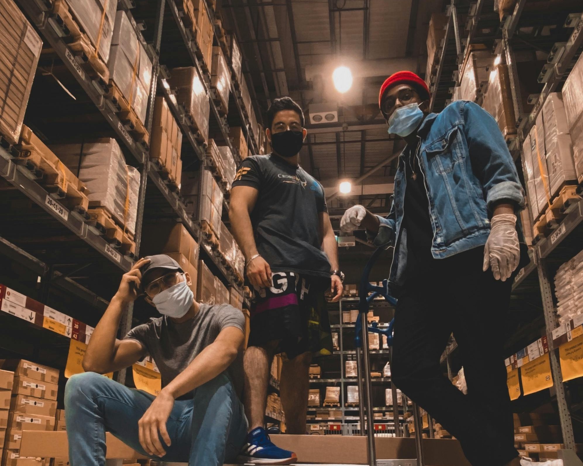 Warehouse staff standing among stacked cartons in a storage aisle
